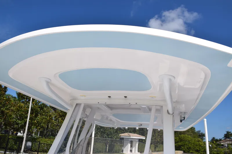 Slide: The Image of 2017 Intrepid 327 boat with sleek white and blue hardtop against a clear sky. - 15