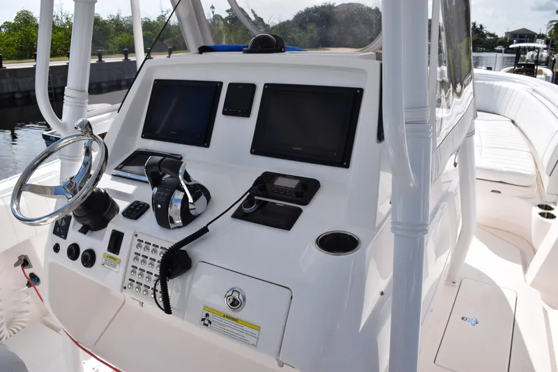 Slide: The Image of 2017 Intrepid 327 boat dashboard with steering wheel and navigation screens. - 25