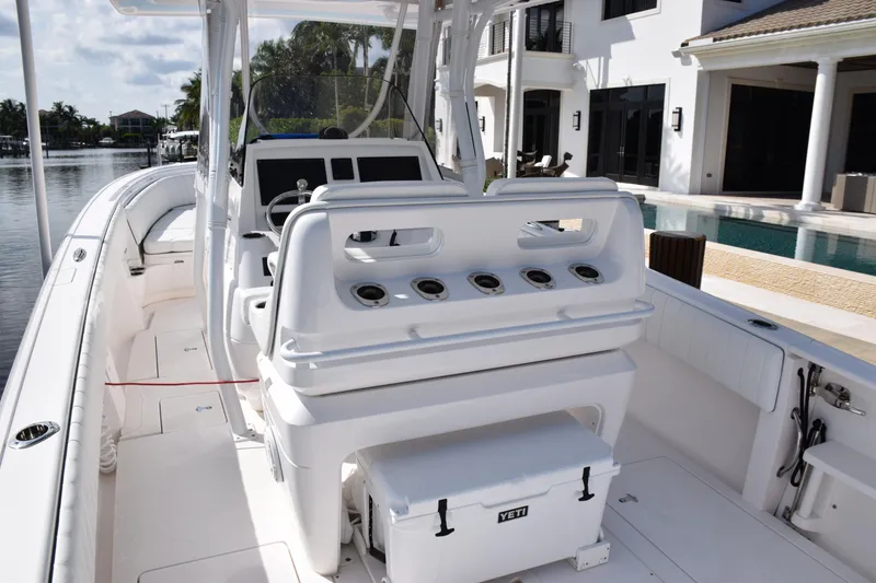 Slide: The Image of 2017 Intrepid 327 boat interior with seating and Yeti cooler, docked by waterfront homes. - 43