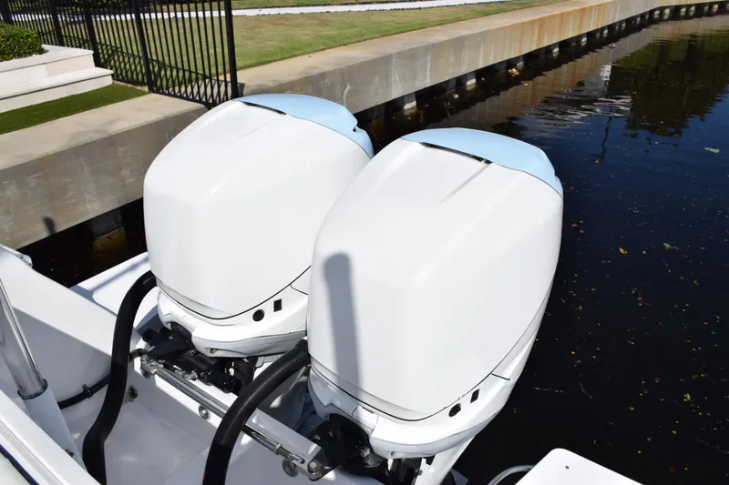 Slide: The Image of Twin outboard engines on a 2017 Intrepid 327 boat by the water. - 44
