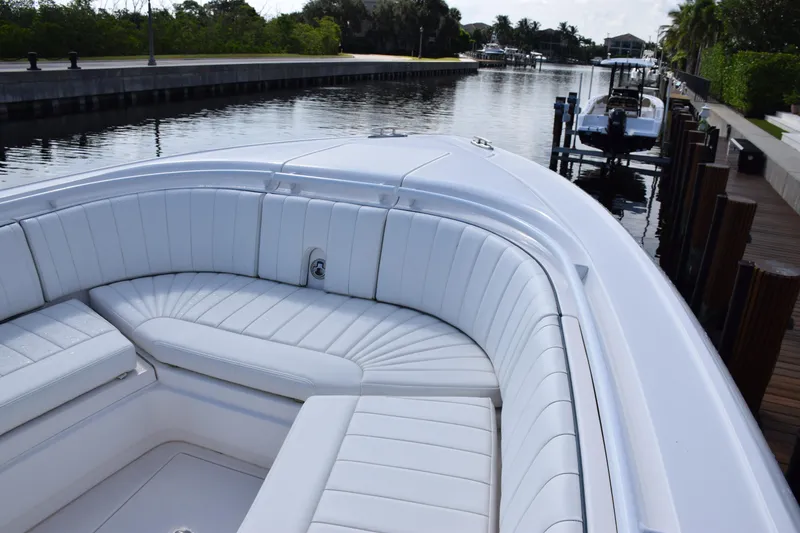 Slide: The Image of 2017 Intrepid 327 boat with white seating, docked by a calm canal. - 8