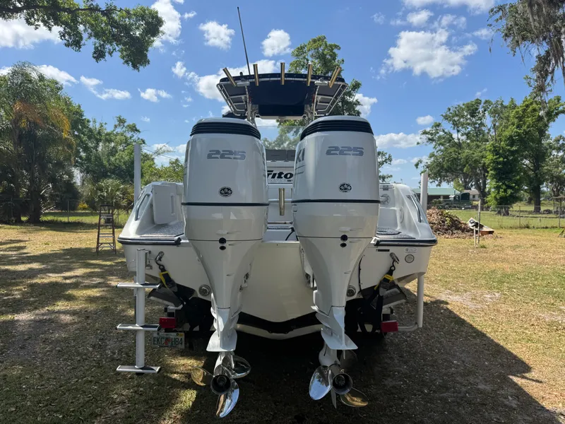 Slide: The Image of 2003 Triton 2690 CC boat with dual 225 horsepower engines, parked outdoors. - 10