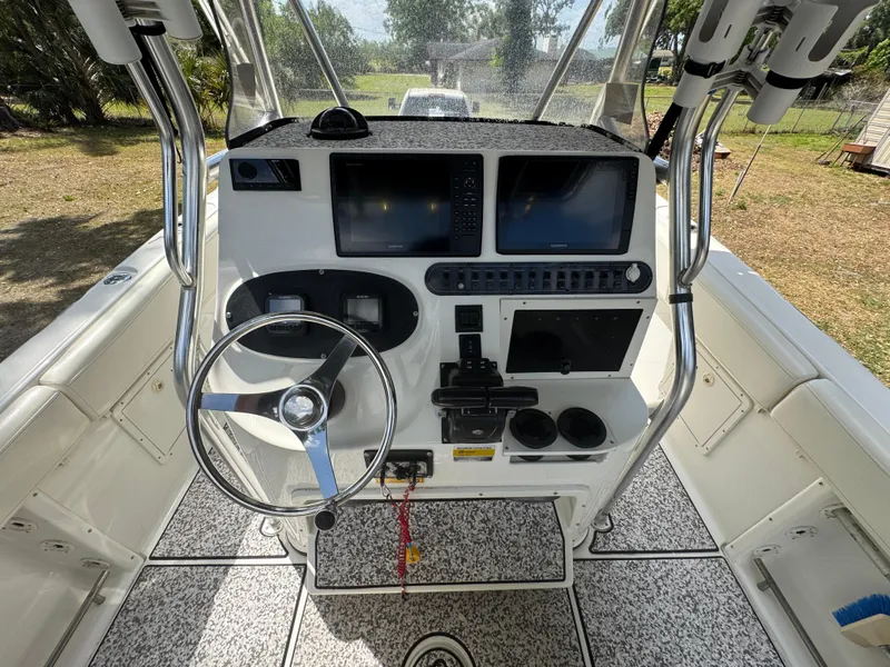 Slide: The Image of 2003 Triton 2690 CC boat console with steering wheel, dual screens, and control panel. - 21