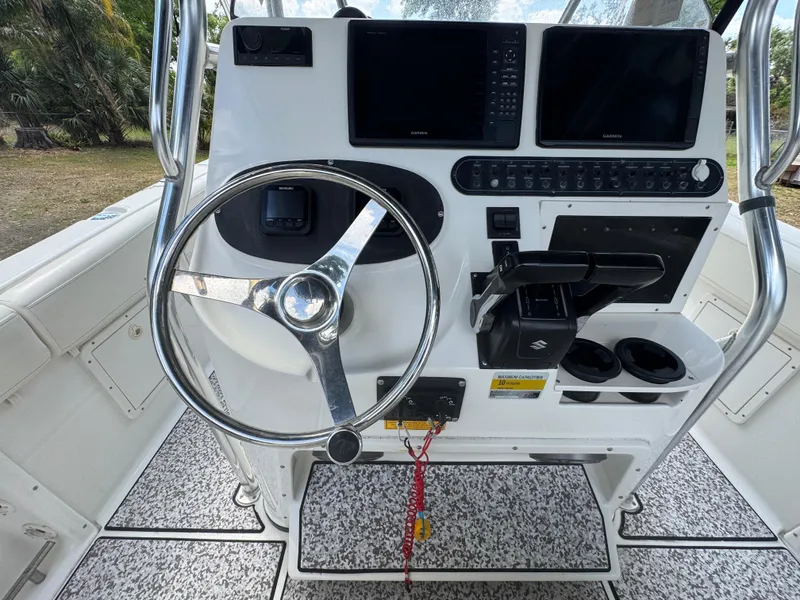 Slide: The Image of 2003 Triton 2690 CC boat console with steering wheel and navigation equipment. - 22