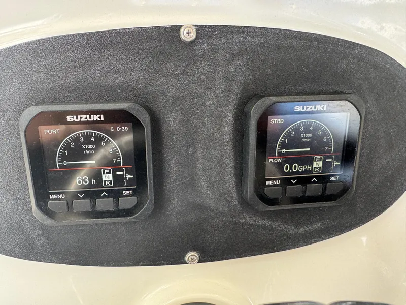 Slide: The Image of Suzuki engine gauges on a 2003 Triton 2690 CC boat dashboard. - 24