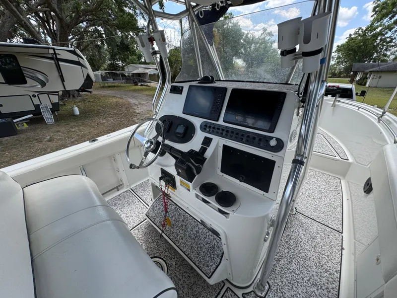 Slide: The Image of 2003 Triton 2690 CC boat cockpit with steering wheel and navigation controls. - 25
