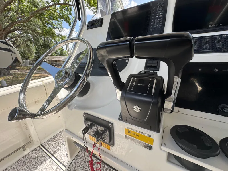 Slide: The Image of 2003 Triton 2690 CC boat cockpit with steering wheel and controls. - 26