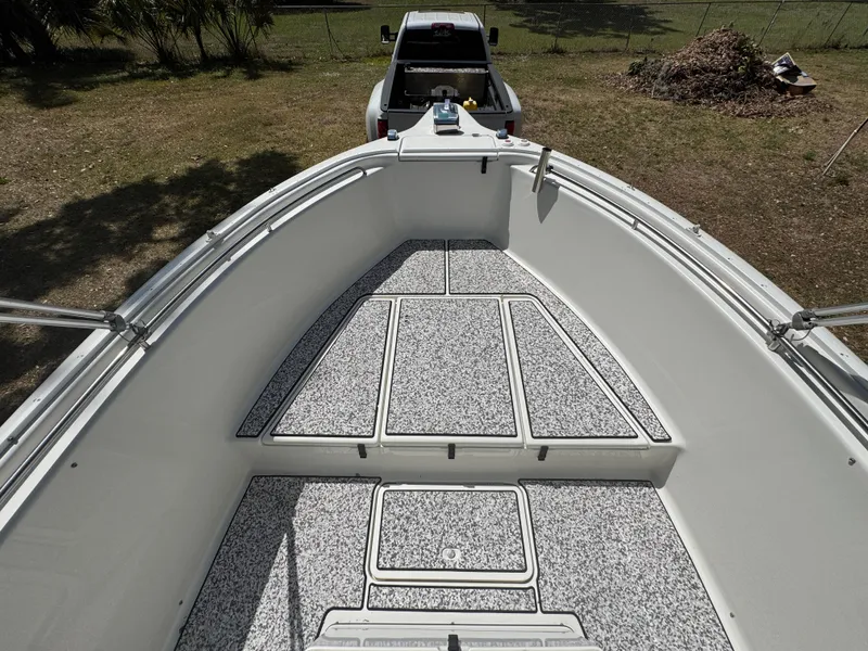 Slide: The Image of 2003 Triton 2690 CC boat interior with speckled flooring, parked on grass. - 33