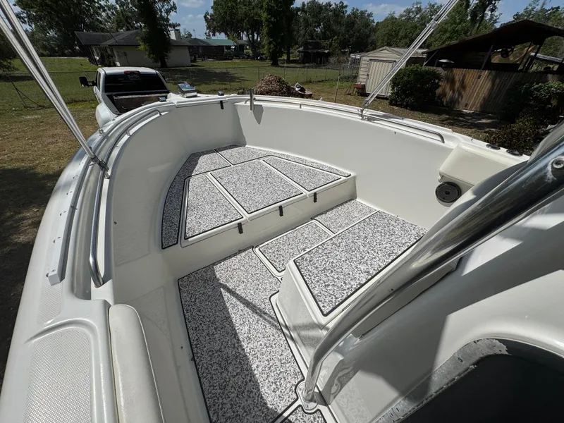 Slide: The Image of 2003 Triton 2690 CC boat interior with cushioned seating and non-slip flooring. - 34