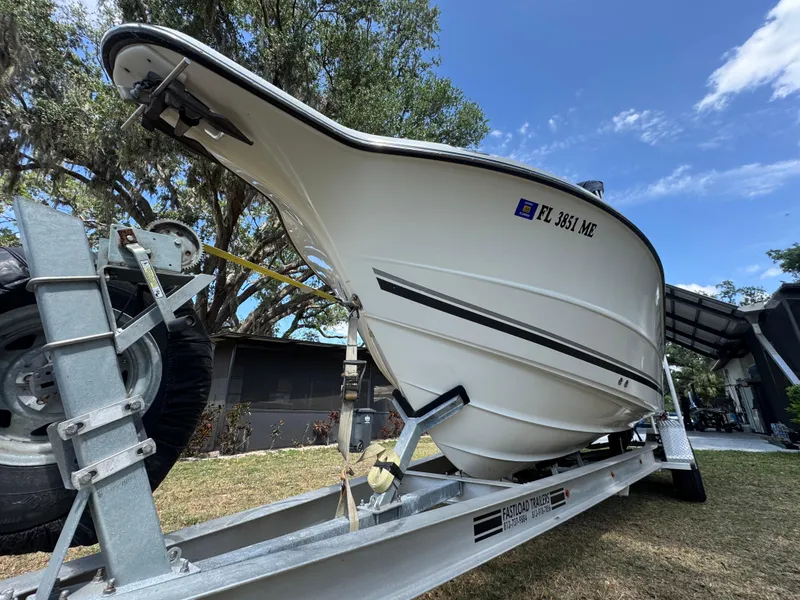 Slide: The Image of 2003 Triton 2690 CC boat on trailer, parked outdoors under a clear blue sky. - 4