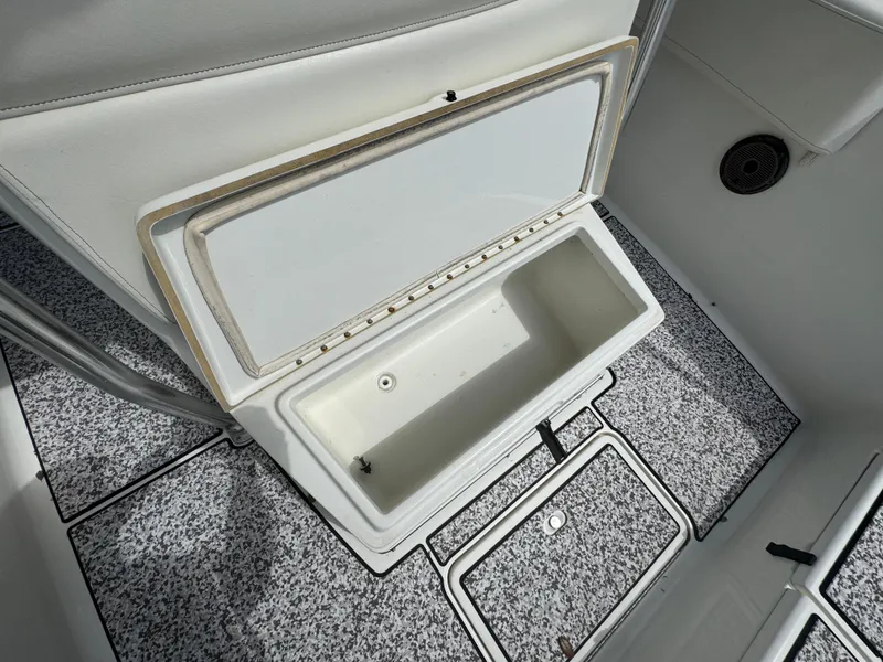 Slide: The Image of Open storage compartment on 2003 Triton 2690 CC boat with speckled flooring. - 40