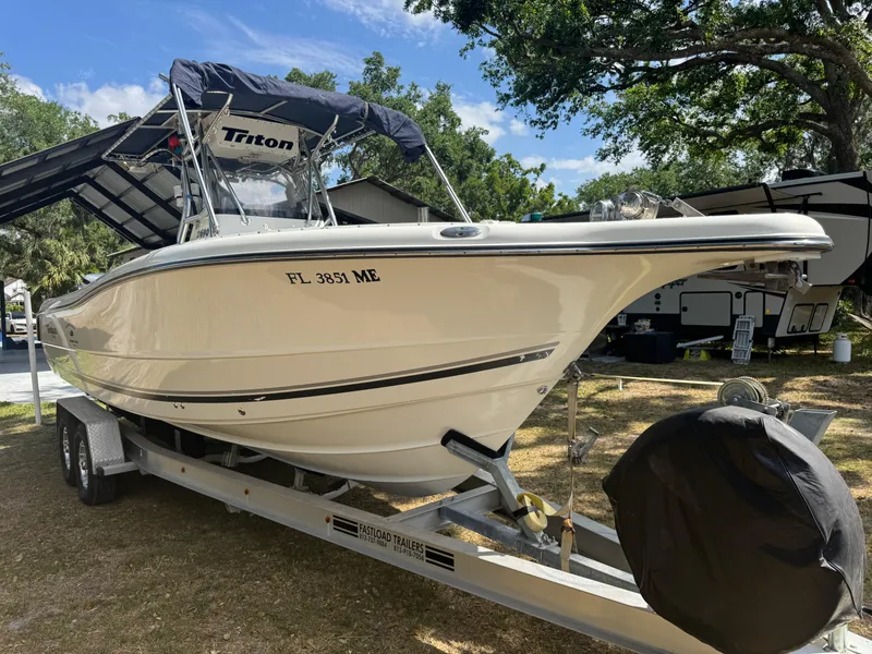 Slide: The Image of 2003 Triton 2690 CC boat on trailer, parked outdoors under trees. - 5