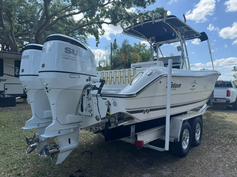 Slide: The Image of 2003 Triton 2690 CC boat on trailer with dual outboard motors, parked outdoors. - 7