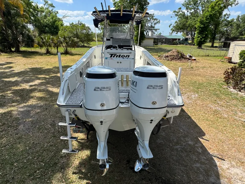 Slide: The Image of 2003 Triton 2690 CC boat with dual Suzuki 225 engines, parked on grass. - 9