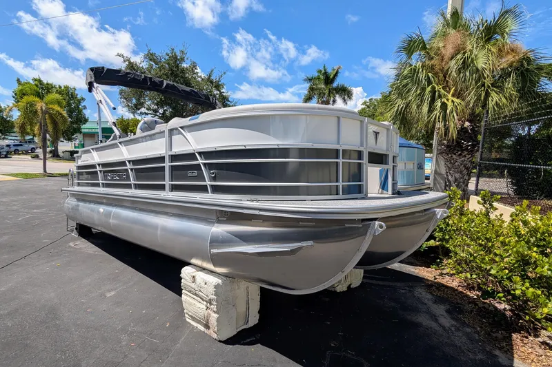 Slide: The Image of 2026 Trifecta 22TRFC LE pontoon boat parked outdoors on a sunny day. - 3