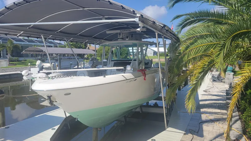 The Image of 2023 Wellcraft 352 Fisherman boat docked under a canopy, surrounded by palm trees. - 0