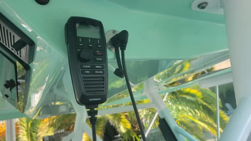 Slide: The Image of VHF radio on 2023 Wellcraft 352 Fisherman boat, with palm trees in the background. - 11