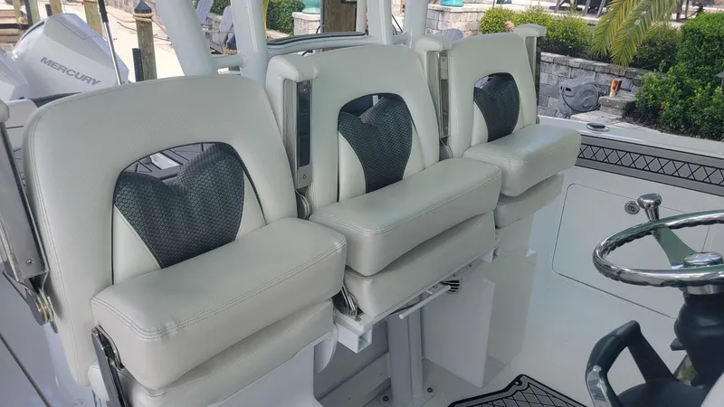 Slide: The Image of 2023 Wellcraft 352 Fisherman boat seats with white cushions and black accents. - 12
