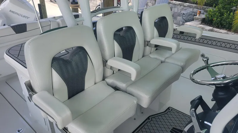 Slide: The Image of 2023 Wellcraft 352 Fisherman boat interior with three cushioned seats and steering wheel. - 13