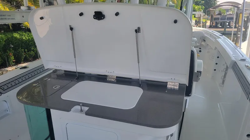 Slide: The Image of 2023 Wellcraft 352 Fisherman boat with open storage compartment and sleek design. - 18