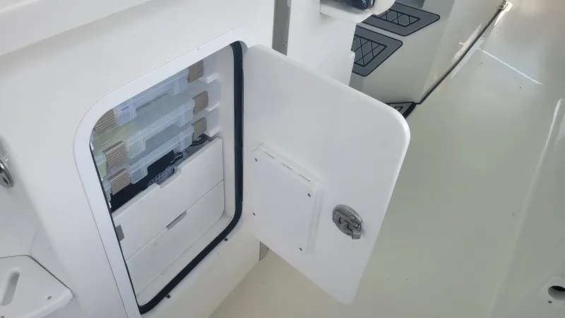 Slide: The Image of 2023 Wellcraft 352 Fisherman boat storage compartment with open door and organized interior. - 32