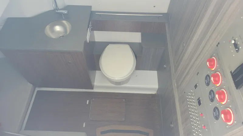 Slide: The Image of 2023 Wellcraft 352 Fisherman boat interior with toilet, sink, and control panel. - 34