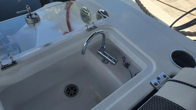 Slide: The Image of 2023 Wellcraft 352 Fisherman boat sink with chrome faucet and cup holder. - 40