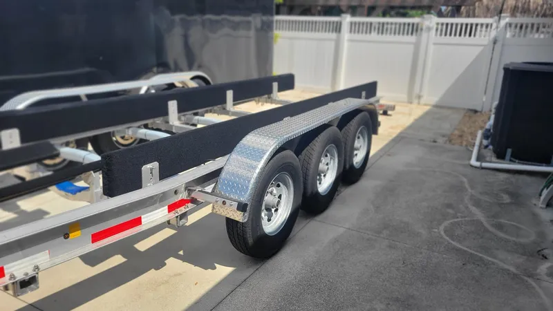 Slide: The Image of Triple-axle trailer for 2023 Wellcraft 352 Fisherman boat, parked on concrete surface. - 48