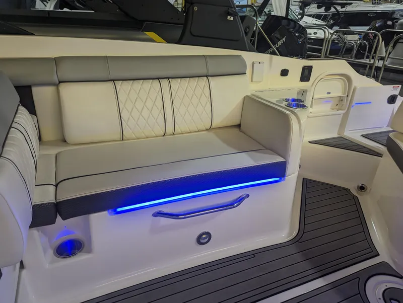 Slide: The Image of 2017 Sea Ray SDX 270 boat interior with cushioned seating and blue LED lighting. - 18