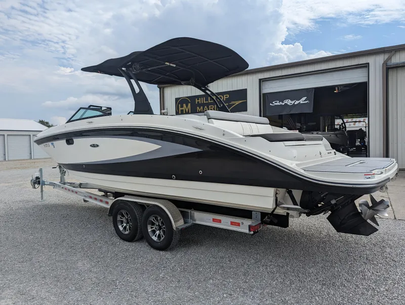 Slide: The Image of 2017 Sea Ray SDX 270 boat on trailer, parked outside dealership under cloudy sky. - 2