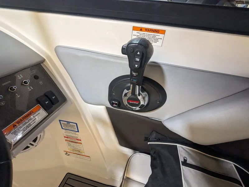 Slide: The Image of 2017 Sea Ray SDX 270 boat control panel with throttle lever and warning labels. - 26