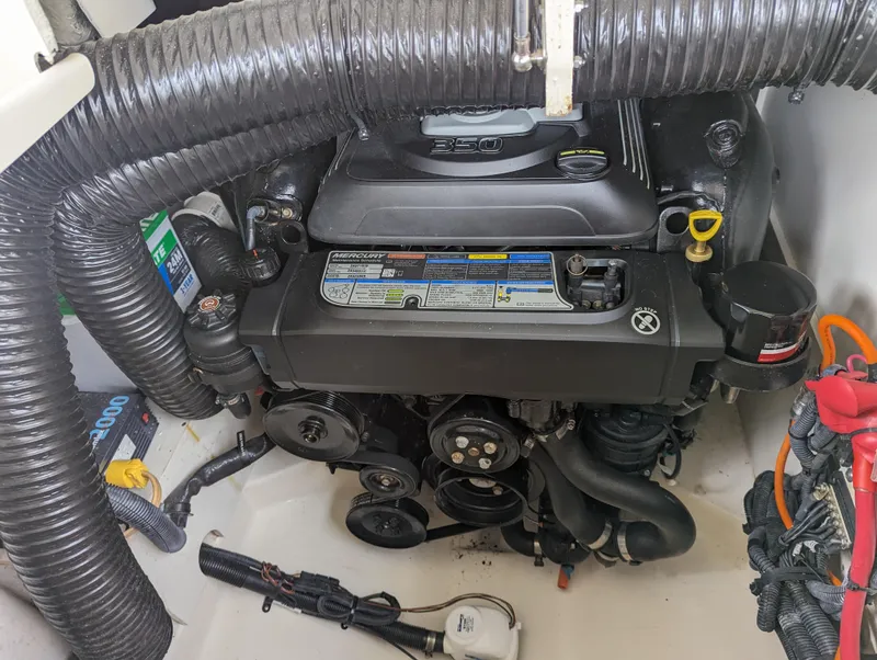 Slide: The Image of Engine compartment of a 2017 Sea Ray SDX 270 boat, showcasing mechanical components and hoses. - 28