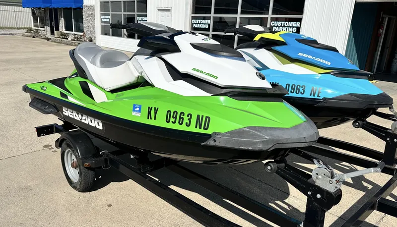 Slide: The Image of 2015 Sea-Doo GTI SE 130 jet skis in green and blue on trailers. - 3