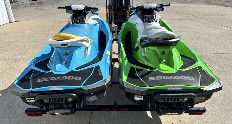Slide: The Image of Two 2015 Sea-Doo GTI SE 130 jet skis, blue and green, parked on a trailer. - 5