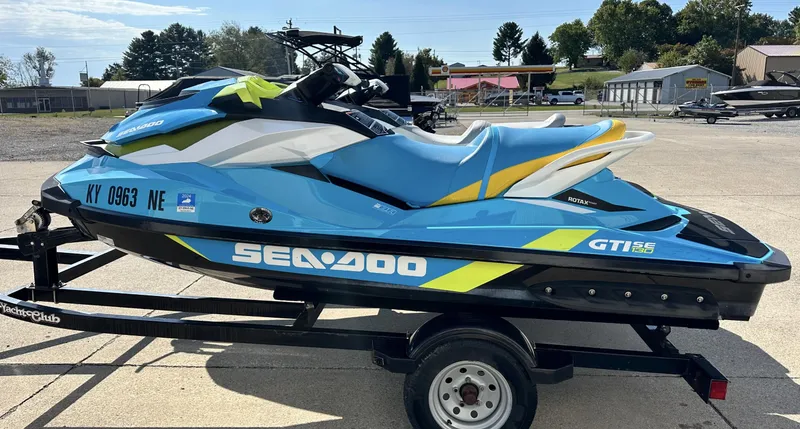 Slide: The Image of 2015 Sea-Doo GTI SE 130 jet ski on trailer, blue and yellow design. - 6