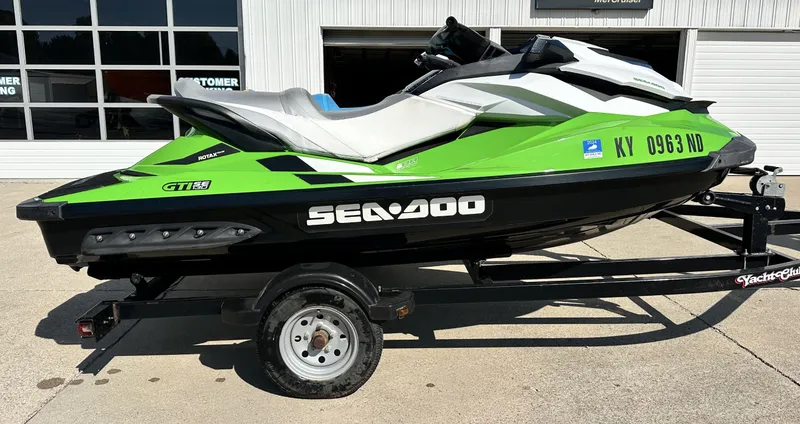 Slide: The Image of 2015 Sea-Doo GTI SE 130 jet ski in green and black on a trailer. - 8