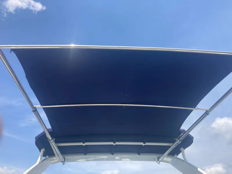 Slide: The Image of 2019 Cruisers Yachts 338 bimini top against a clear blue sky. - 11