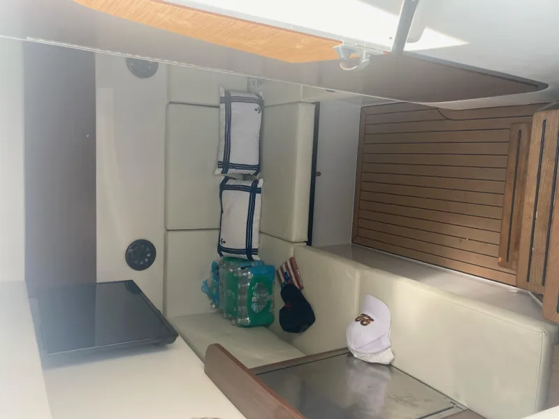 Slide: The Image of Interior of 2019 Cruisers Yachts 338 with seating, cushions, and wooden flooring. - 15