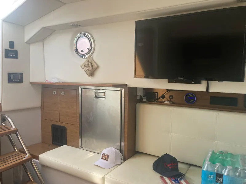 Slide: The Image of Interior of 2019 Cruisers Yachts 338 with TV, seating, and storage. - 16