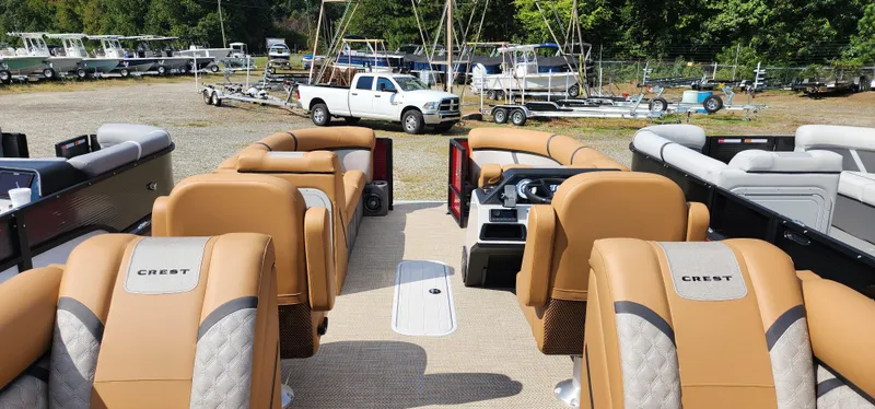 Slide: The Image of 2025 Crest CLASSIC 220 SLC pontoon boat with tan seating, parked outdoors. - 3