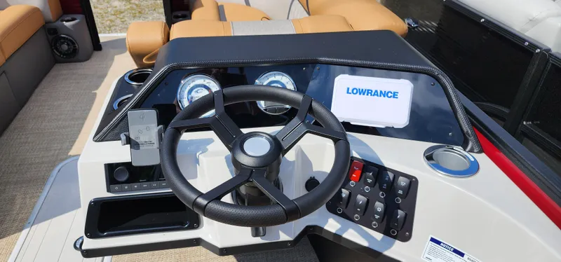 Slide: The Image of 2025 Crest CLASSIC 220 SLC boat dashboard with steering wheel and Lowrance display. - 4
