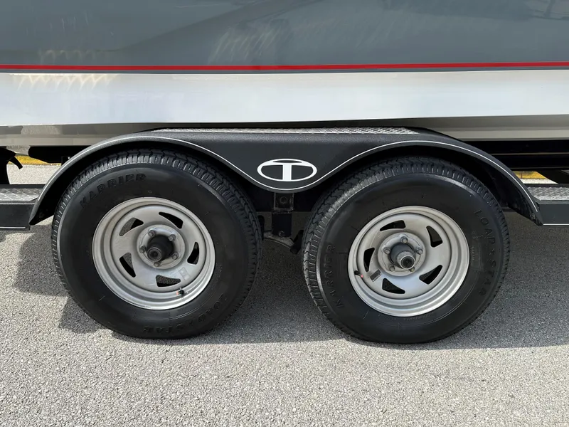 Slide: The Image of 2021 Tahoe 700 trailer wheels on asphalt, featuring dual tires and sleek design. - 12