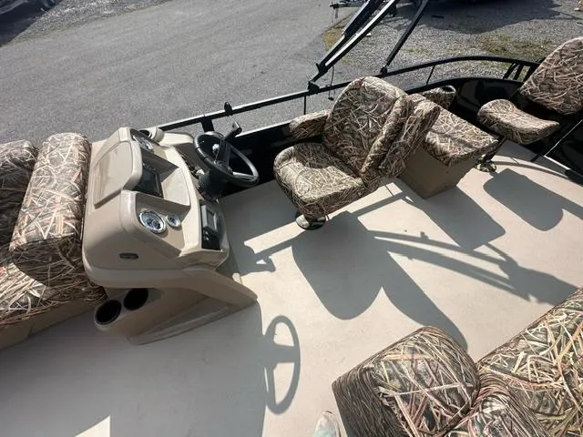 Slide: The Image of 2025 Starcraft LX 22 F boat interior with camo-patterned seating and steering console. - 5