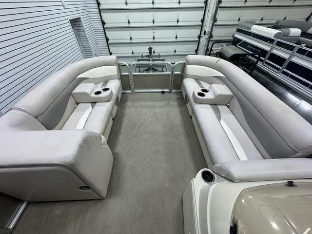 Slide: The Image of 2014 Sweetwater SW 2286 SLC pontoon boat interior with beige seating and cup holders. - 13