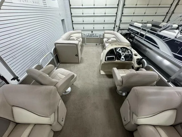 Slide: The Image of 2014 Sweetwater SW 2286 SLC pontoon boat interior with beige seating and steering console. - 9