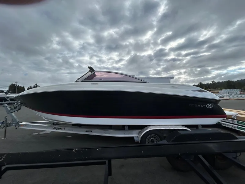 The Image of 2010 Cobalt 262 boat on trailer under cloudy sky. - 0