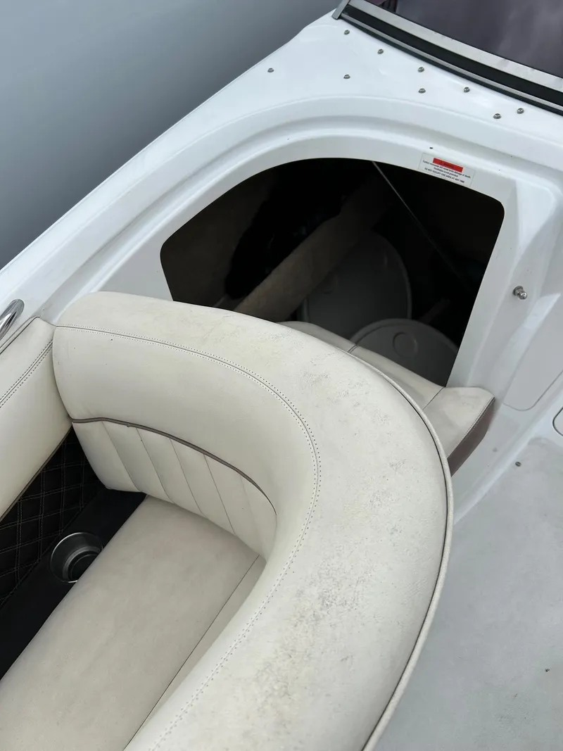 Slide: The Image of 2010 Cobalt 262 boat interior with white leather seating and storage compartment. - 16