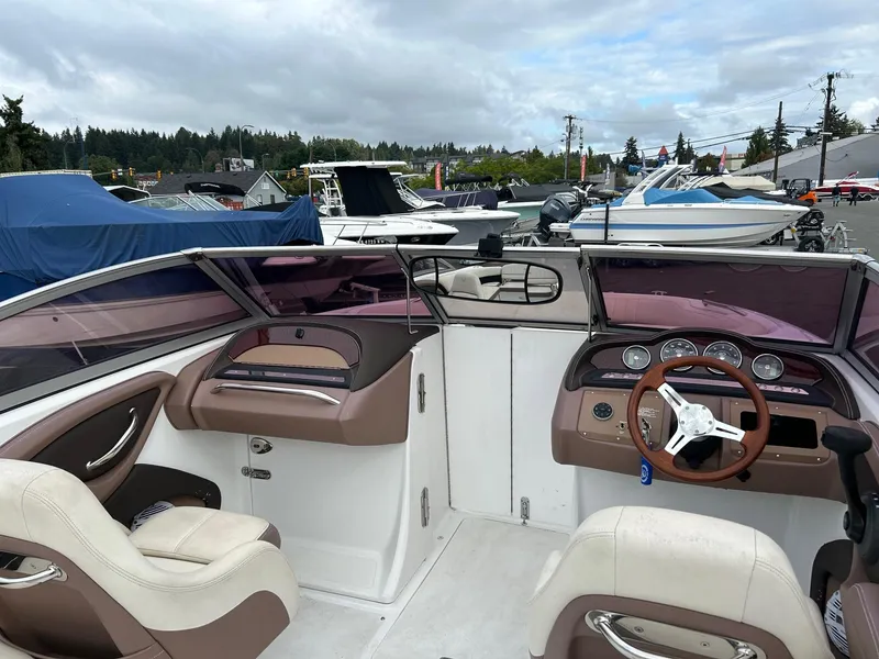 Slide: The Image of 2010 Cobalt 262 boat interior with steering wheel and dashboard, docked among other boats. - 6