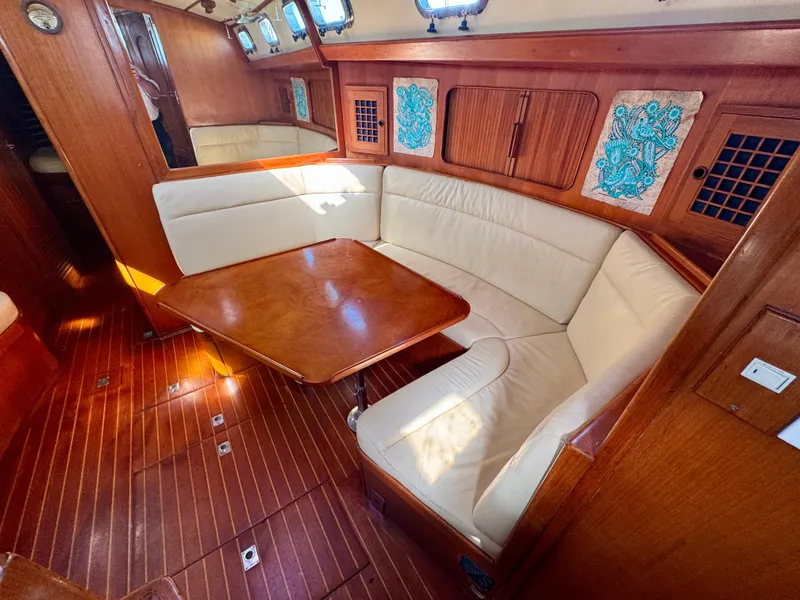 Slide: The Image of 1983 Tayana 52 Aft Cockpit interior with wooden flooring and cream seating. - 10