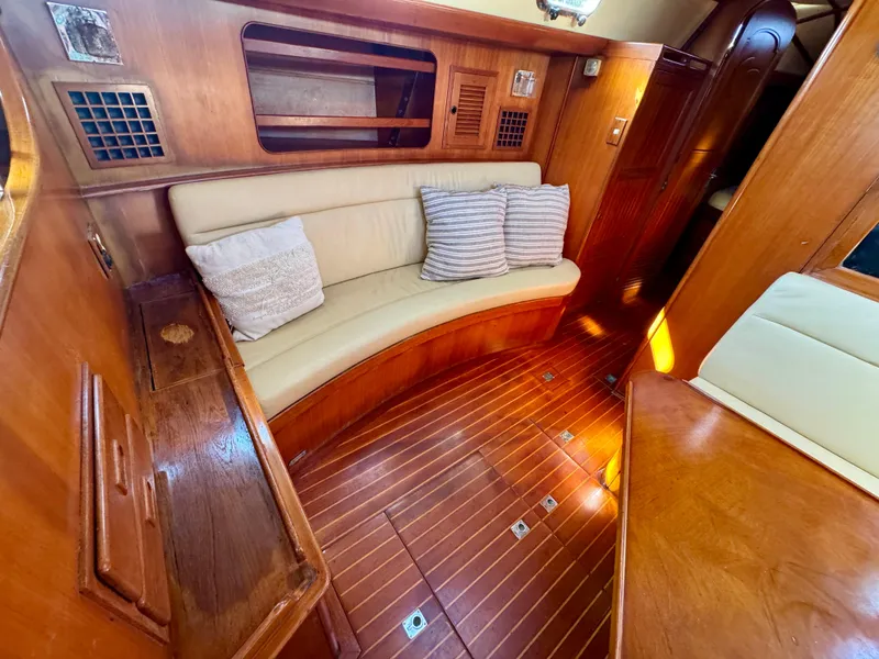 Slide: The Image of 1983 Tayana 52 Aft Cockpit interior with wooden finish and cushioned seating. - 11